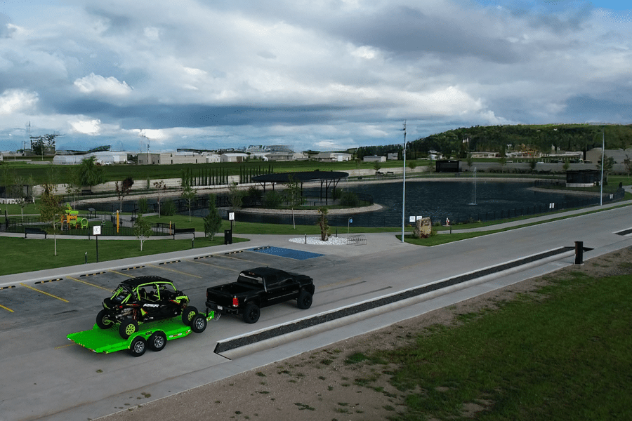 green ATV on green Arrow Trail trailer being hauled by black truck