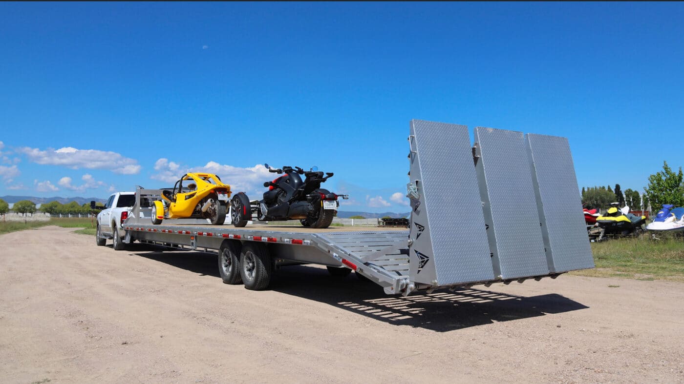 trailer carrying two vehicles from arrow trail