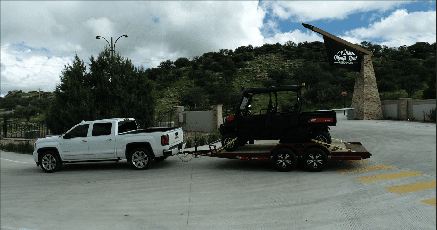 a white truck pulling a 4-wheeler vehicle on a trailer from arrow trail in san bernardino ca