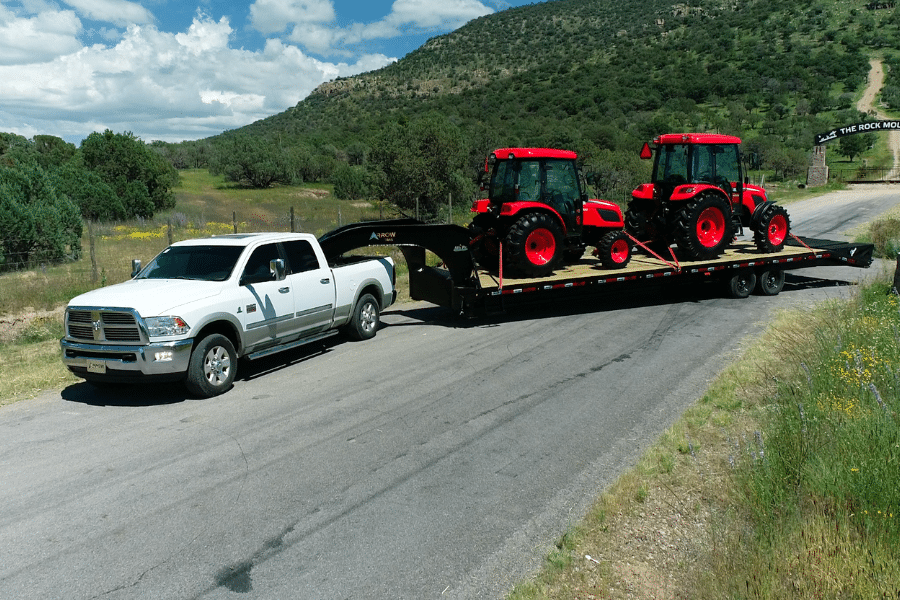 two red trailers on the back of a flatbed gooseneck trailer